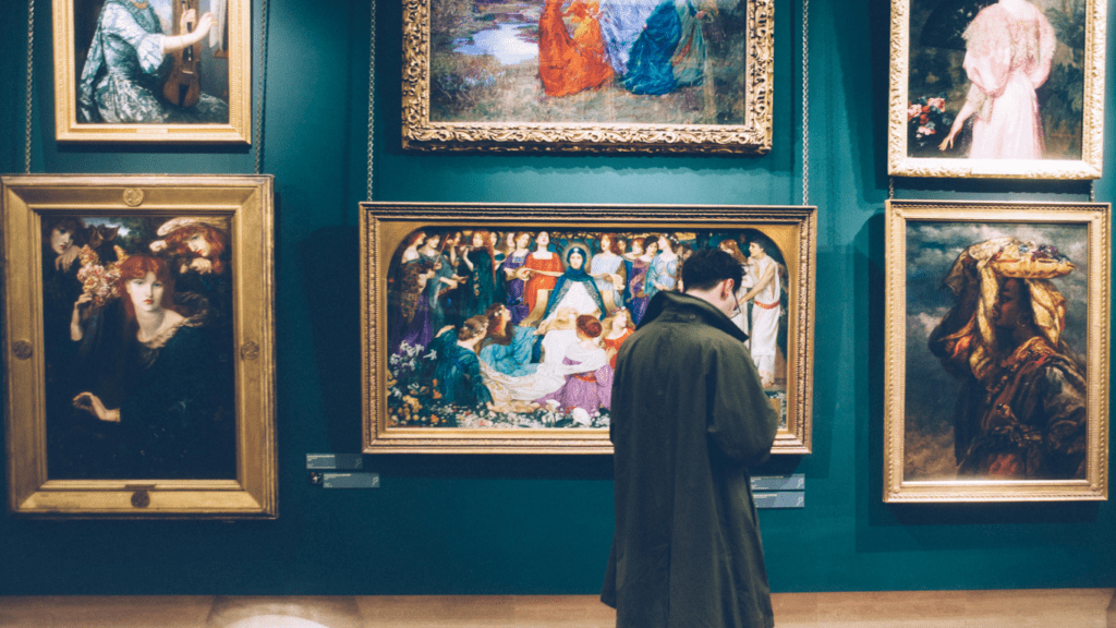 a person looking at paintings in an art museum