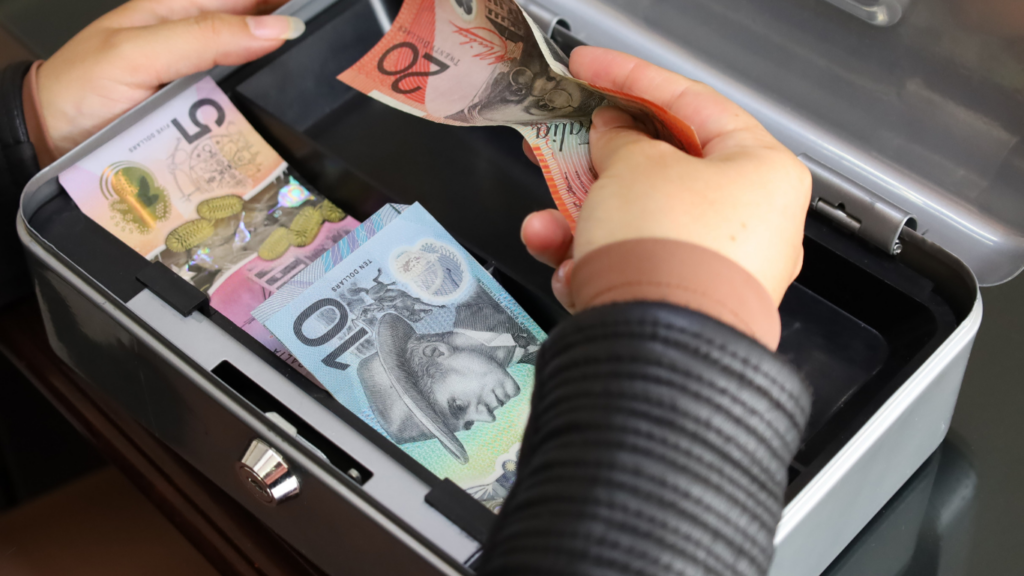 a person putting money into a money box