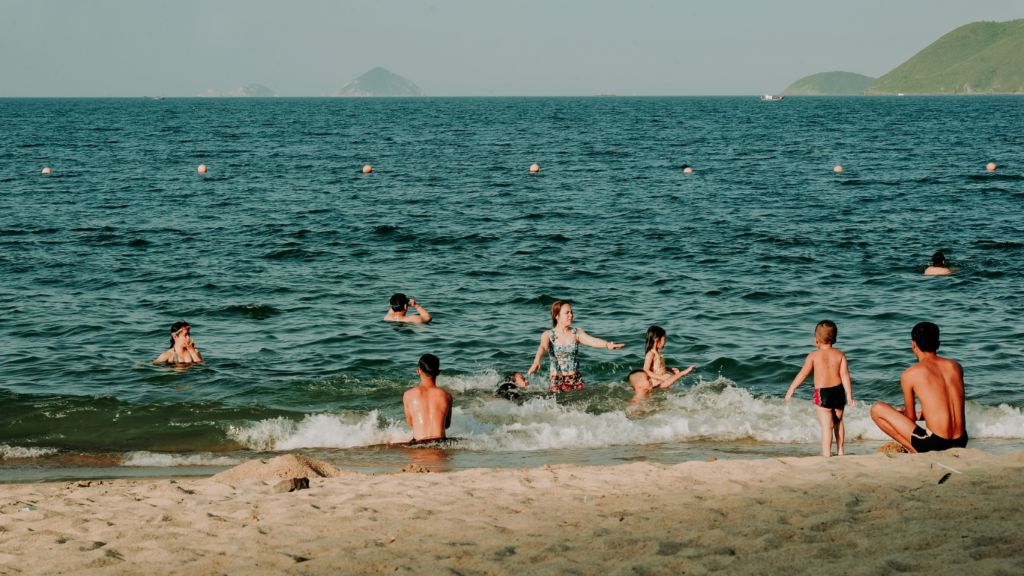 a group of people playing in the water at the beach