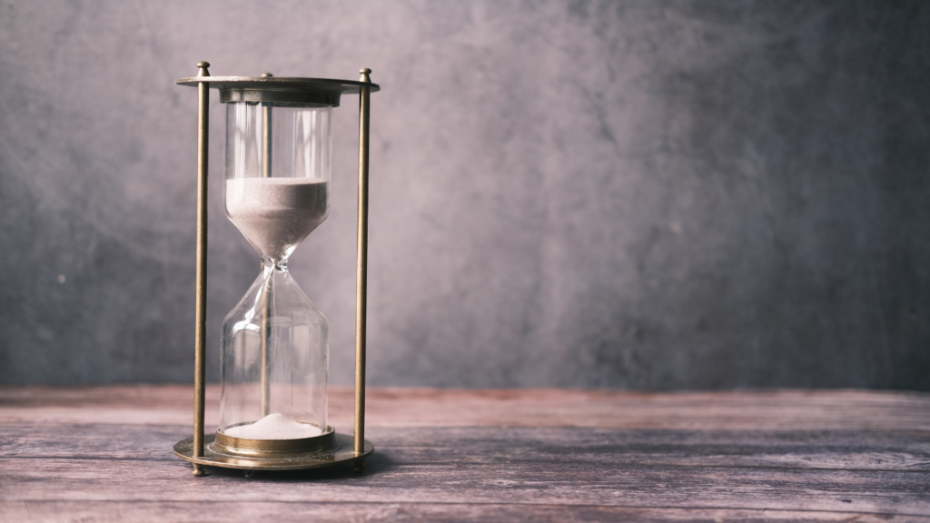 an hourglass sitting on top of a wooden table