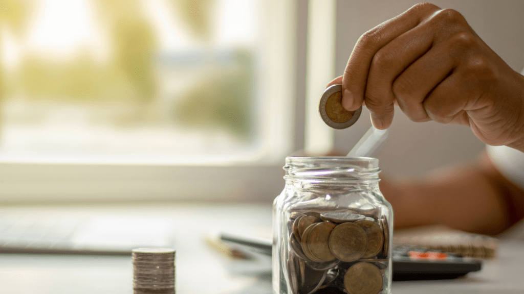 a person is putting a coins in a jar