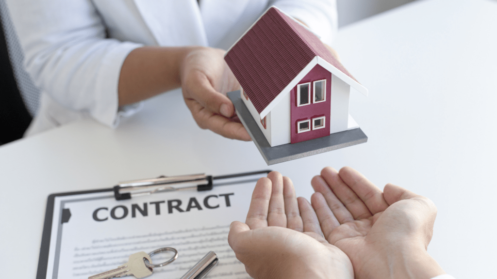 a person holding a contract with a house model on top of it