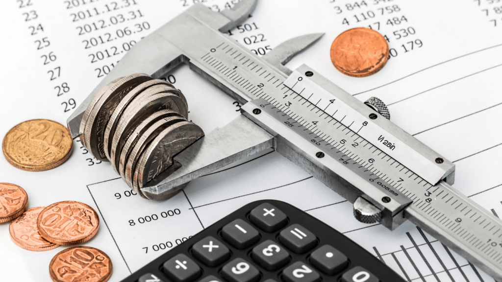 a calculator, pen, and paper are on top of a pile of financial documents