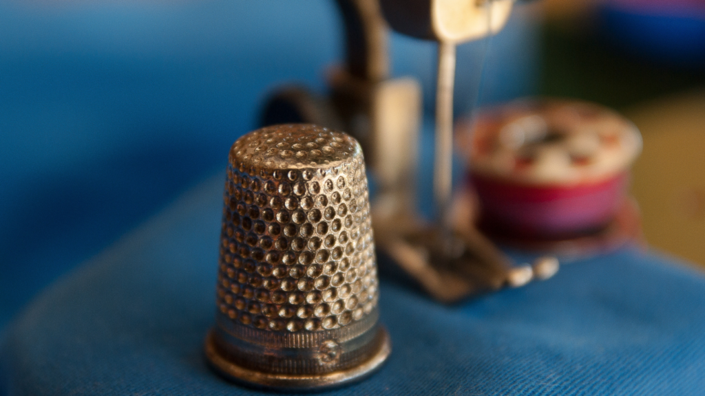 a close up of a sewing machine with blue fabric