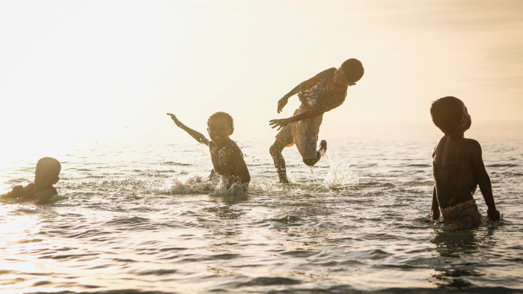 a group of people playing in the water at the beach