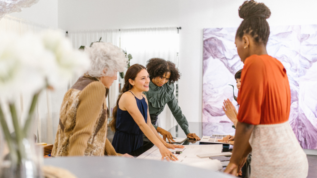 a group of people standing around a table in an office