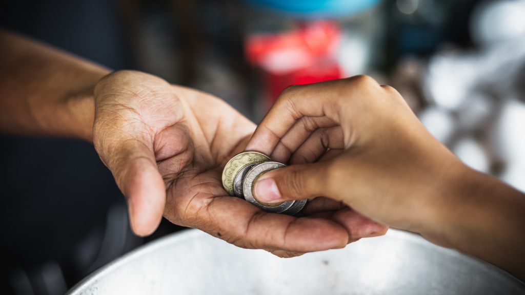 a person handing money to another person at a desk