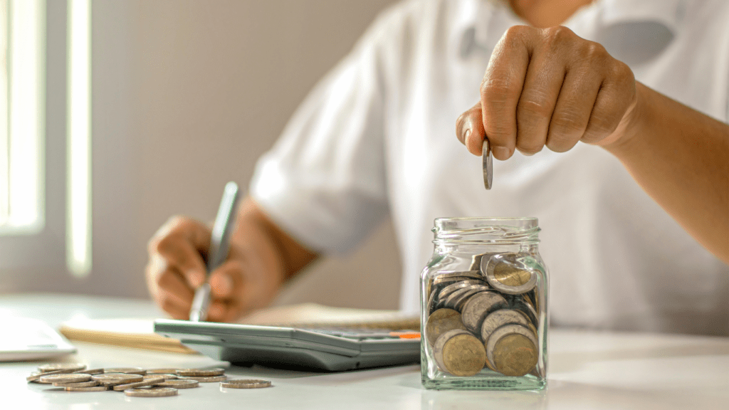 a person is putting a coins in a jar