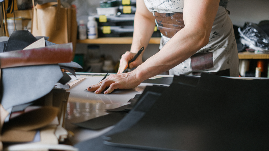 a person is working on a piece of fabric on a table