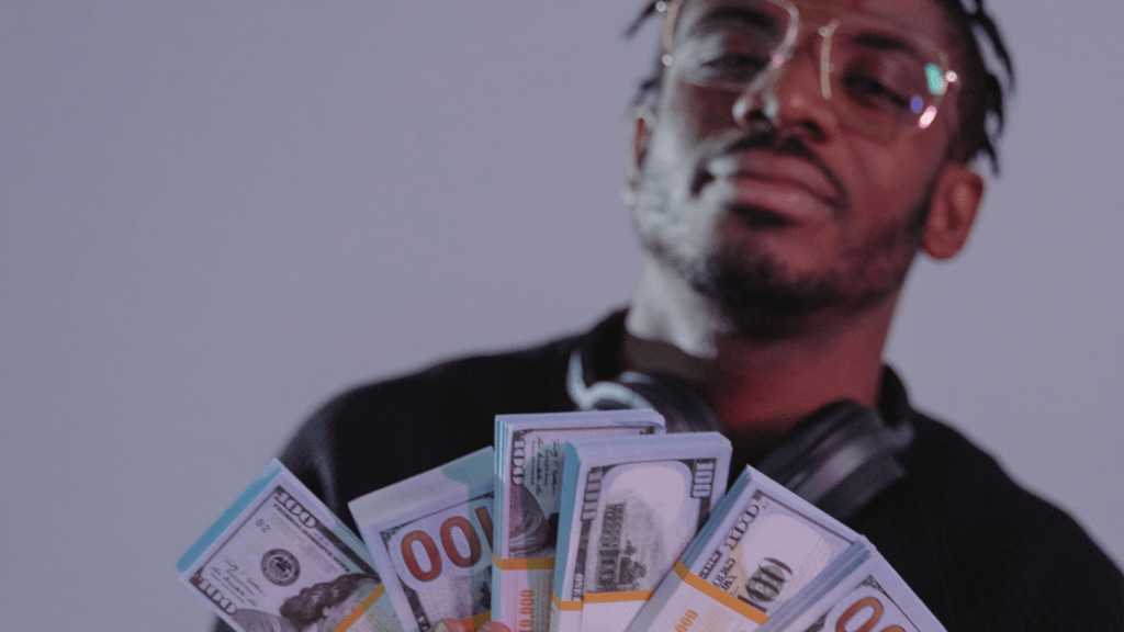 an individual in a suit and tie holding a bunch of money