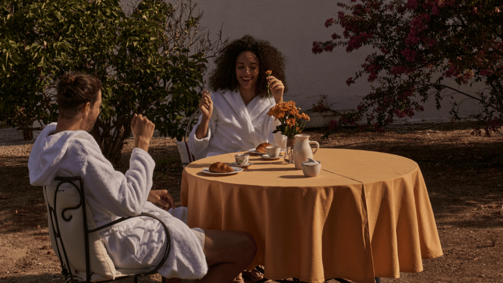 two people sitting in lawn chairs near a pool and palm trees